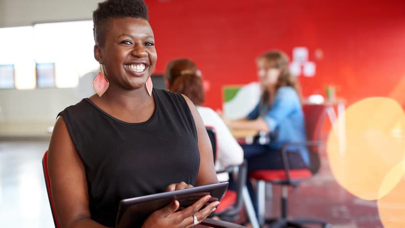 Confident woman smiling in front of a red backdrop