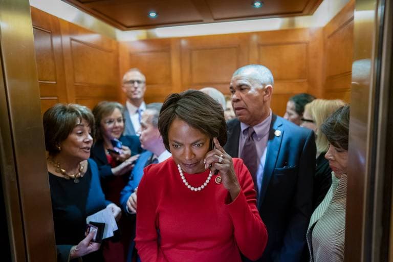 Val Demings in red standing in an elevator