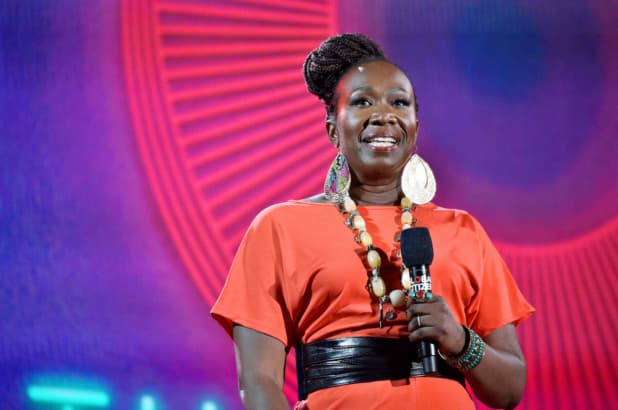 Woman in orange standing with a microphone