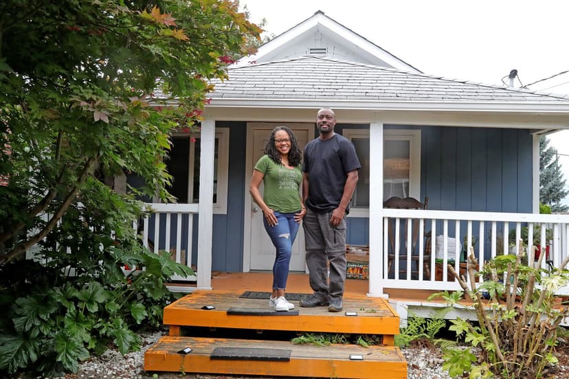 Black homeowners in front of their home