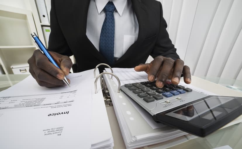 man sitting at a desk with a calculator