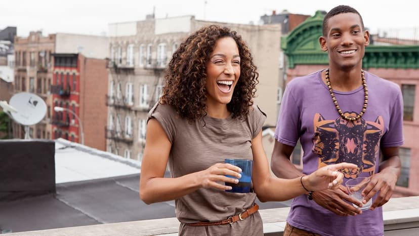 Two young people laughing atop a roof