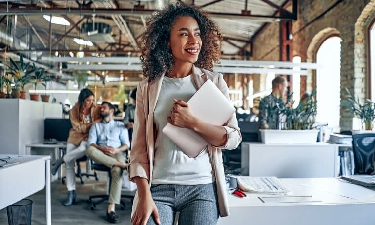 Woman walking with laptop in hand