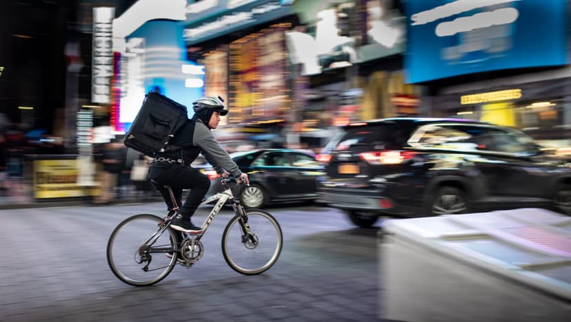 man riding a delivery bike through the streets