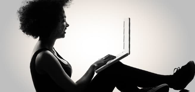 woman balancing laptop on leg