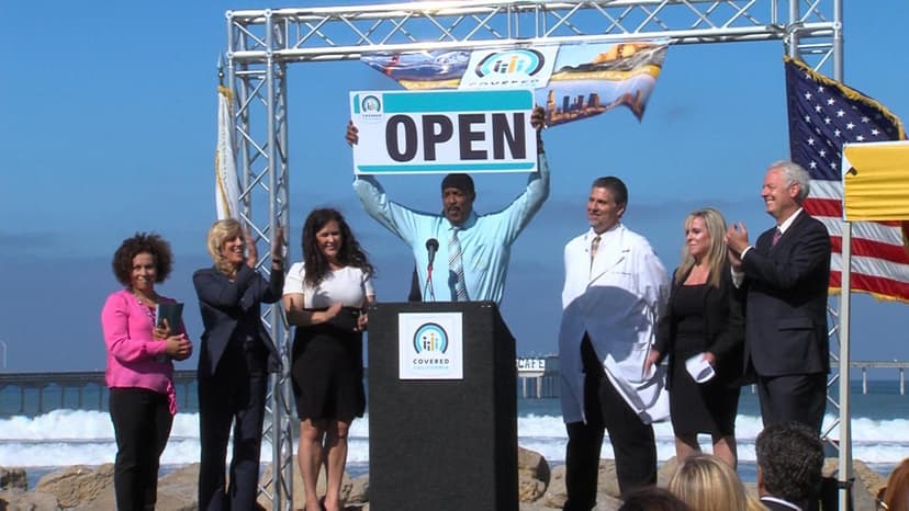 People on stage with "Open" signage