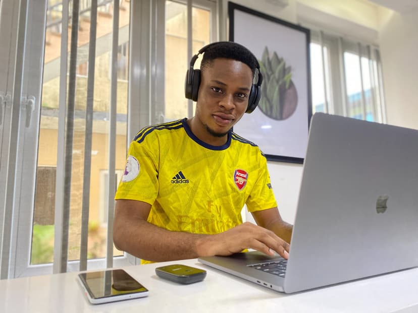 Boy in a yellow shirt at a laptop