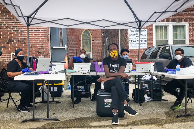 a group of black medical professionals seated outdoors