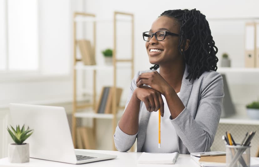 Black woman smiling seated at a desk