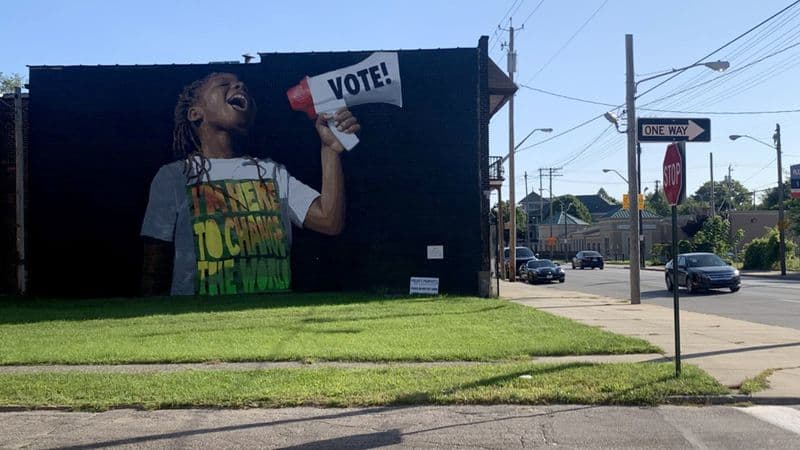 mural on a city street with little boy using a bullhorn