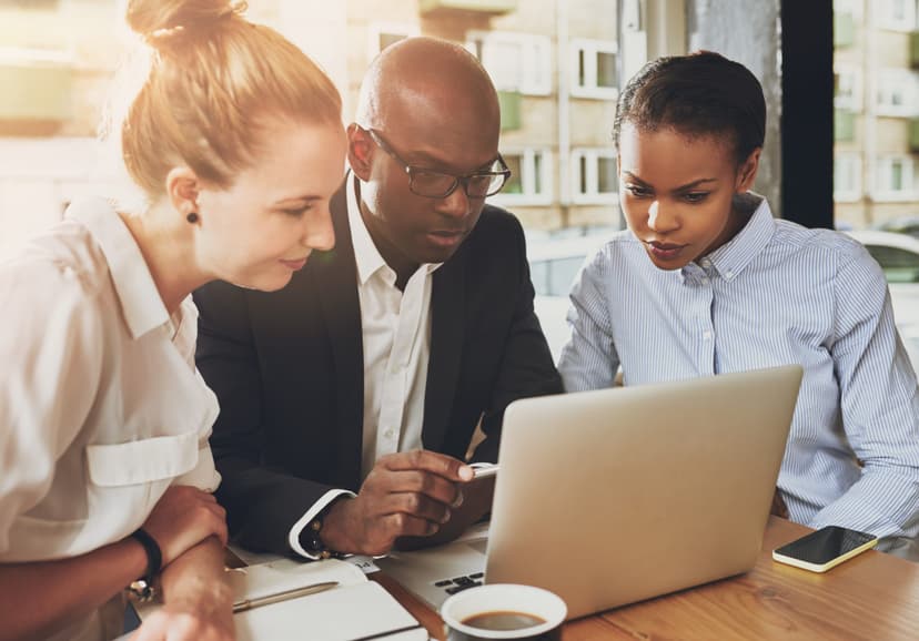 3 colleagues looking into a laptop