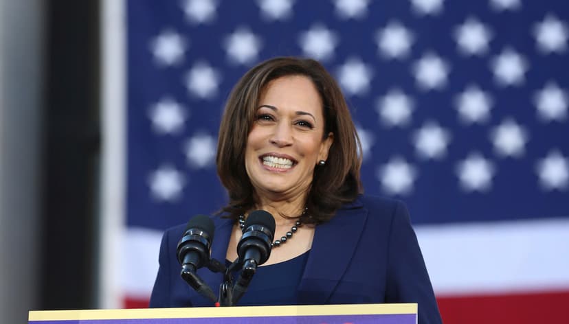 Kamala Harris smiling with the American flag in the backdrop