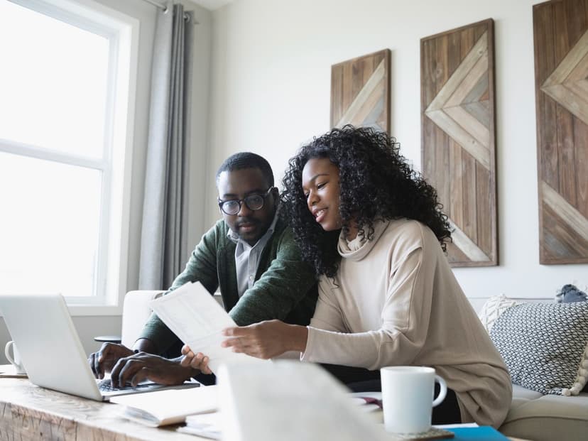 a couple on a couch looking at documents