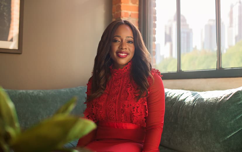 Woman smiling and seated wearing a red dress